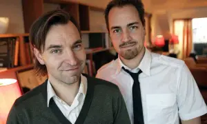 Två män, varav en är Måns Mårlind, poserar framför bokhyllor.