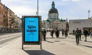 Folksam reklam på en blå skylt i en stadsmiljö. "Sjön suger" står det, med texten "Sparande och försäkring ska inte göra det." under.