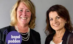 Två leende kvinnor, en med pärlhalsband, den andra med guldsmycken. Johanna Frelin är en av dem.