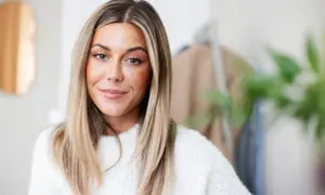 En kvinna med blont hår och en vit tröja, kanske en av Sveriges rikaste influencers.