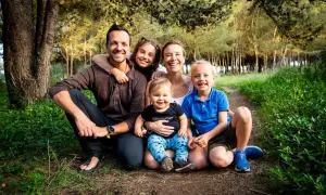 En glad axel swedish family med tre barn i en skog.
