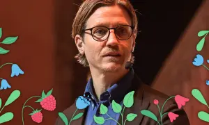 Alexander Lydecker med glasögon och blå skjorta, omgiven av blommor och hallon.