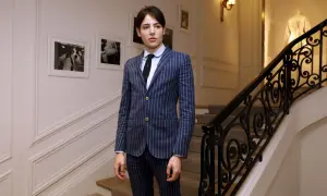 Harry Brant står på en trappa i en randig kostym.
