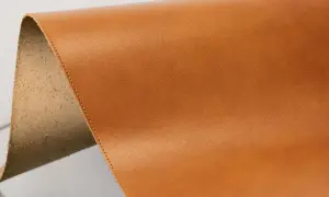 Brun, slät yta av veganläder med en rå, ludden kant.