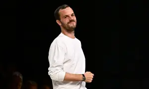 Matthieu Blazy, klädd i en vit långärmad tröja, ler mot kameran.