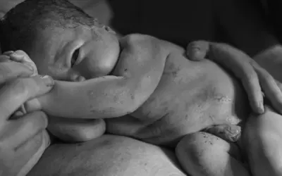 Nyfödd bebis vilar tryggt i famnen. En känsla av lugn och kärlek, som i en Trygg Hansa reklam.