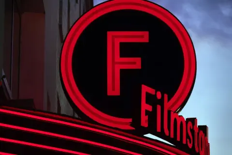 Filmstadens neonbelysta logotyp lyser upp kvällen.