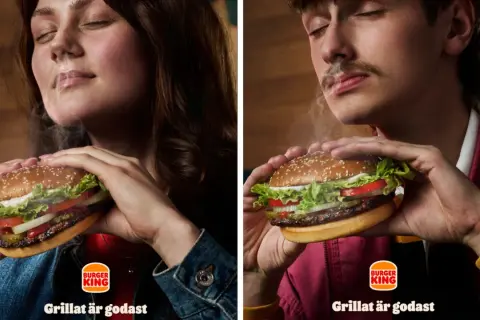 Två personer njuter av en saftig hamburgare från Burger King. Röken stiger från burgaren och skapar en härlig atmosfär.