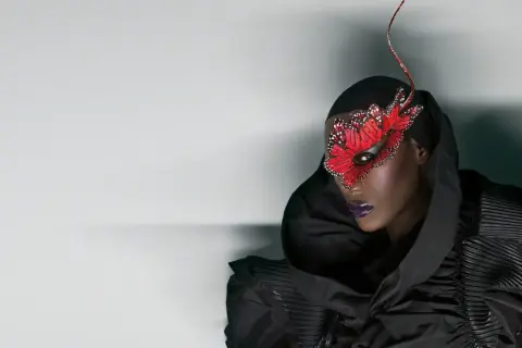 Grace Jones idag, med en dramatisk fjärilsmask och en voluminös svart klänning.