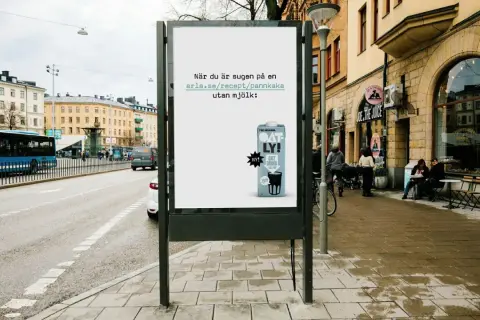 Oatly reklam på en reklamtavla i stadsmiljö. Texten uppmanar till att baka pannkakor utan mjölk.