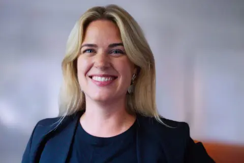 Amanda Oxell ler mot kameran, klädd i en svart kavaj och med blont hår.