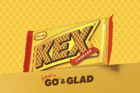 En gul och röd förpackning med texten "KEX CHOKLAD" och "fortsätt va GO' & GLAD".