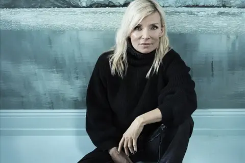 Bea Uusma, känd för sitt arbete inom barnkirurgi, sitter framför en isig bakgrund.