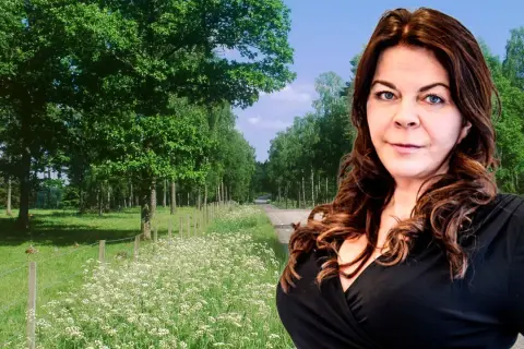 Jennifer Wegerup i en vacker sommarmiljö med en väg kantad av träd och blommor.