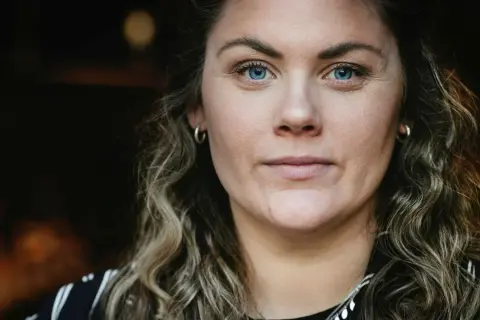 Julia Karlsten med blå ögon och lockigt hår.