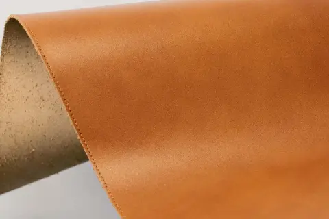 Brun, slät yta av veganläder med en rå, ludden kant.