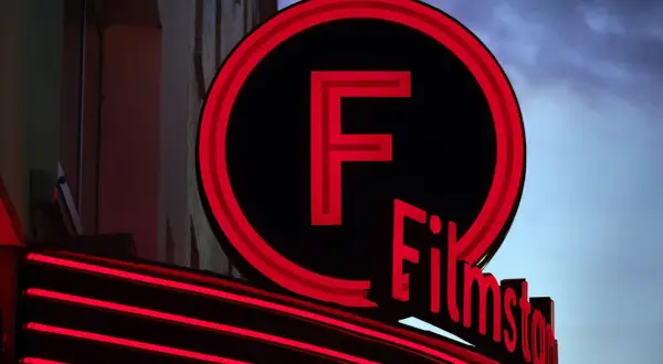 Filmstadens neonbelysta logotyp lyser upp kvällen.