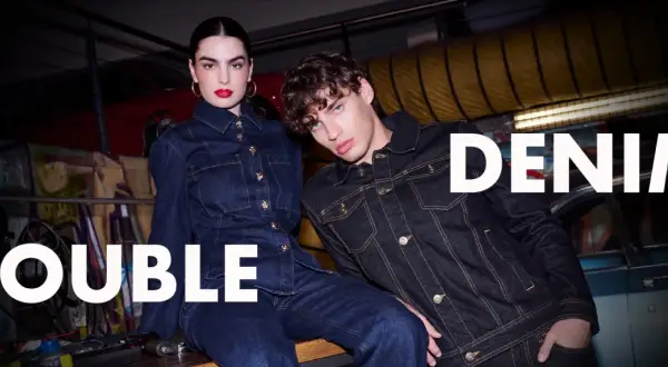 Två modeller i mörka denimkläder, en kvinna och en man, visar upp den senaste denim on denim-trenden.