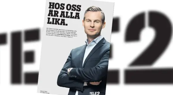 En man i kostym ler mot kameran i en Telenor reklam. Texten lyder "Hos oss är alla lika".
