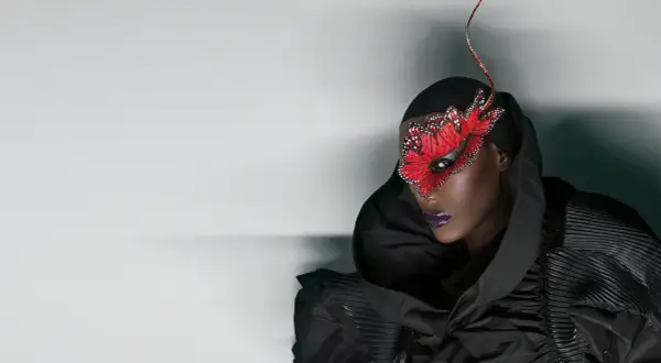 Grace Jones idag, med en dramatisk fjärilsmask och en voluminös svart klänning.