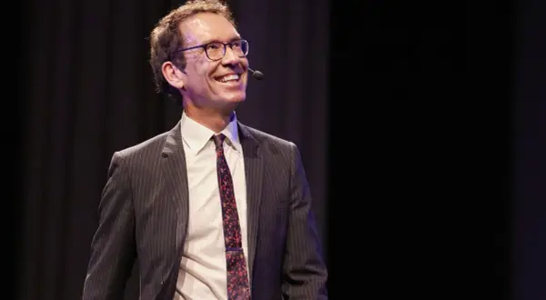 Byron Sharp ler glatt på scenen, klädd i kostym och slips, redo att dela med sig av sina insikter.