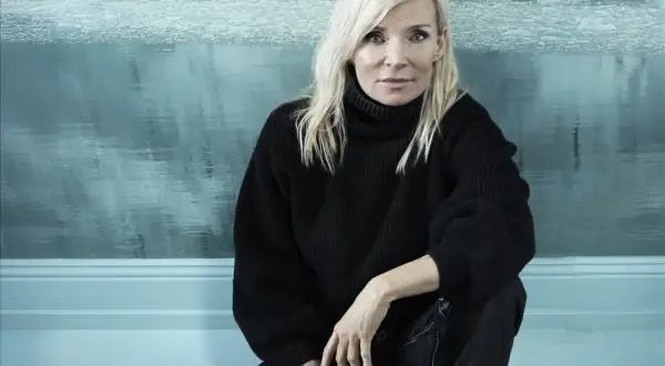 Bea Uusma, känd för sitt arbete inom barnkirurgi, sitter framför en isig bakgrund.