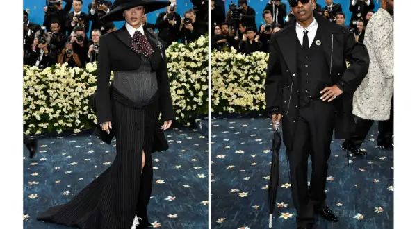 Rihanna, gravid, poserar i en dramatisk svart outfit med hatt. Bredvid henne står A$AP Rocky i en elegant svart kostym.