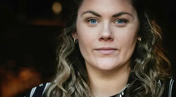Julia Karlsten med blå ögon och lockigt hår.
