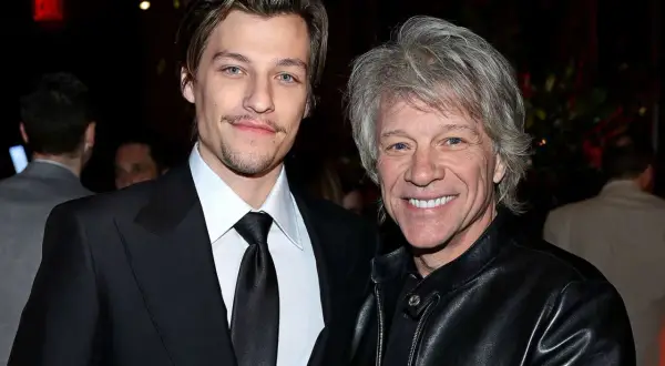 Jesse Bongiovi och Jon Bon Jovi ler mot kameran. Jesse bär en svart kostym och Jon en svart läderjacka.