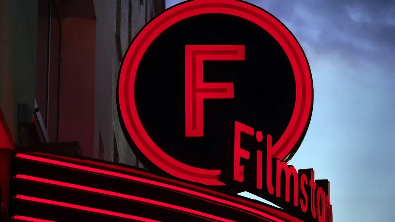 Filmstadens neonbelysta logotyp lyser upp kvällen.