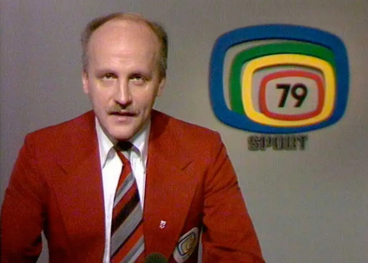 Arne Hegerfors i röd kavaj med slips, bredvid en logotyp med siffran 79 och texten SPORT.