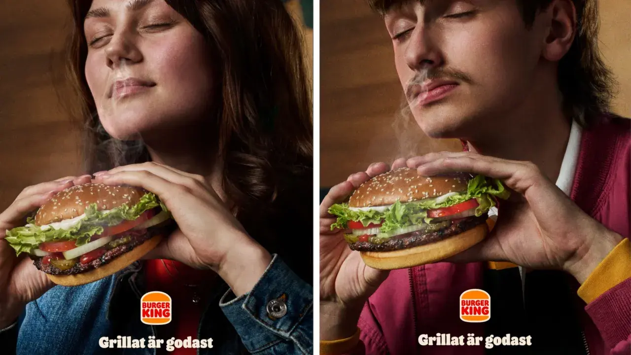 Två personer njuter av en saftig hamburgare från Burger King. Röken stiger från burgaren och skapar en härlig atmosfär.