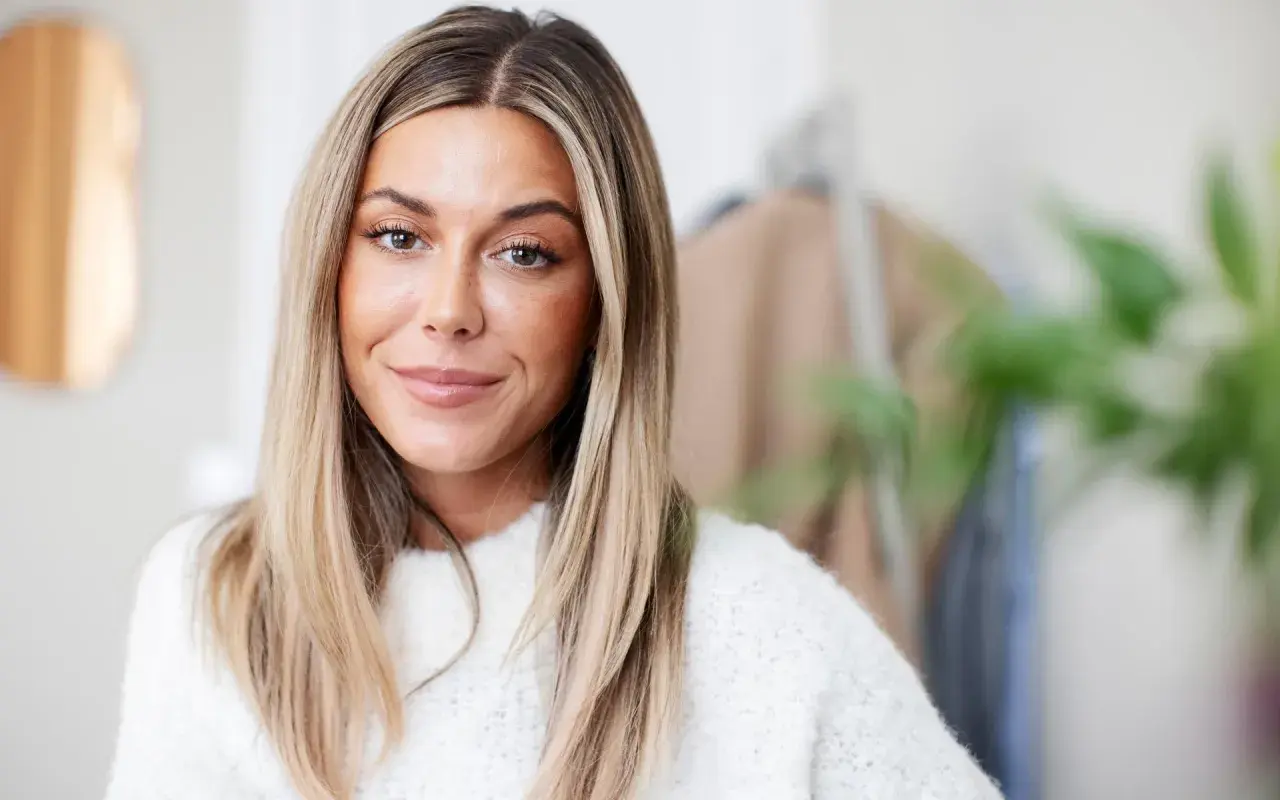 En kvinna med blont hår och en vit tröja, kanske en av Sveriges rikaste influencers.