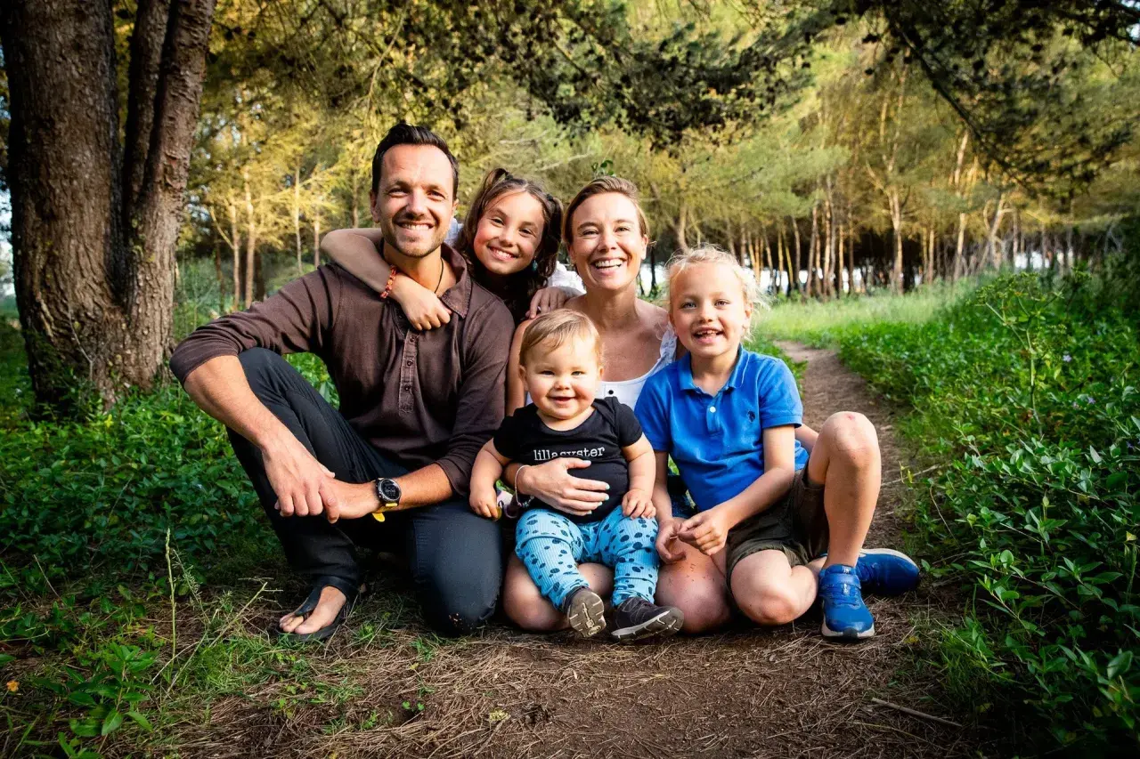 En glad axel swedish family med tre barn i en skog.