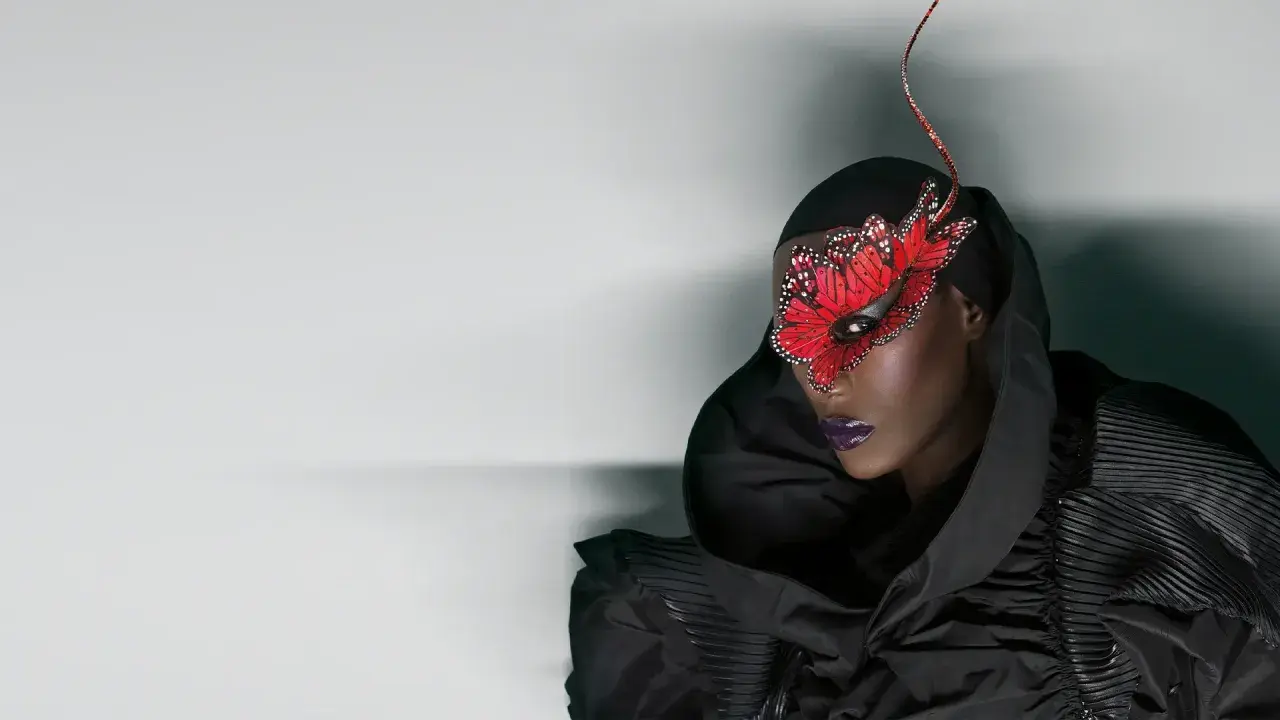 Grace Jones idag, med en dramatisk fjärilsmask och en voluminös svart klänning.