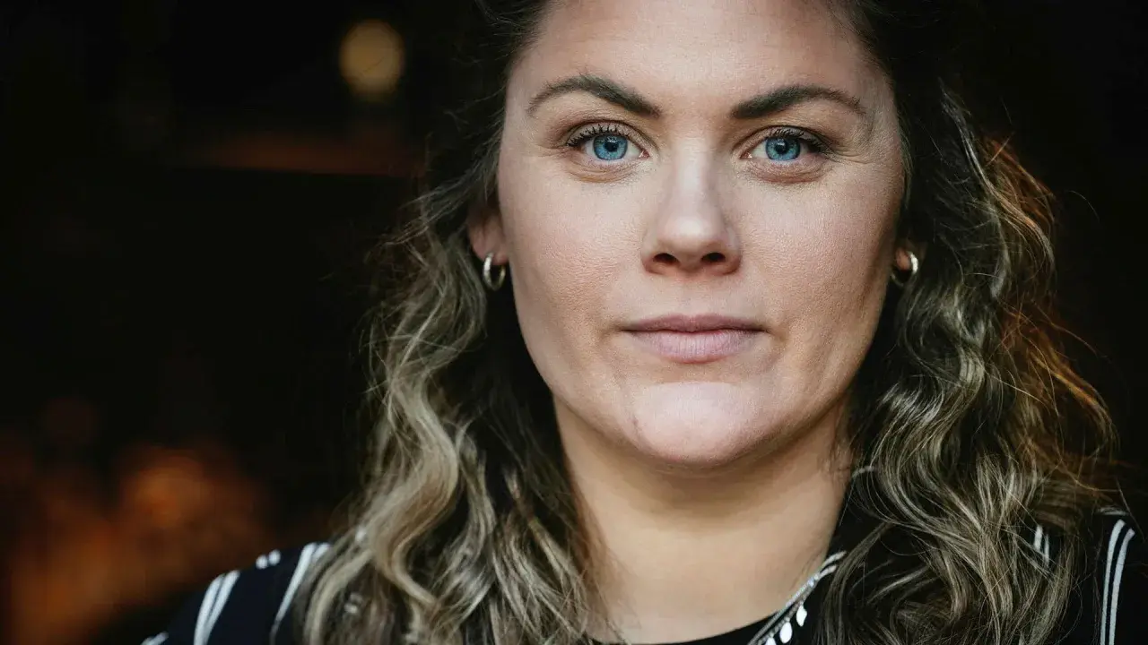 Julia Karlsten med blå ögon och lockigt hår.