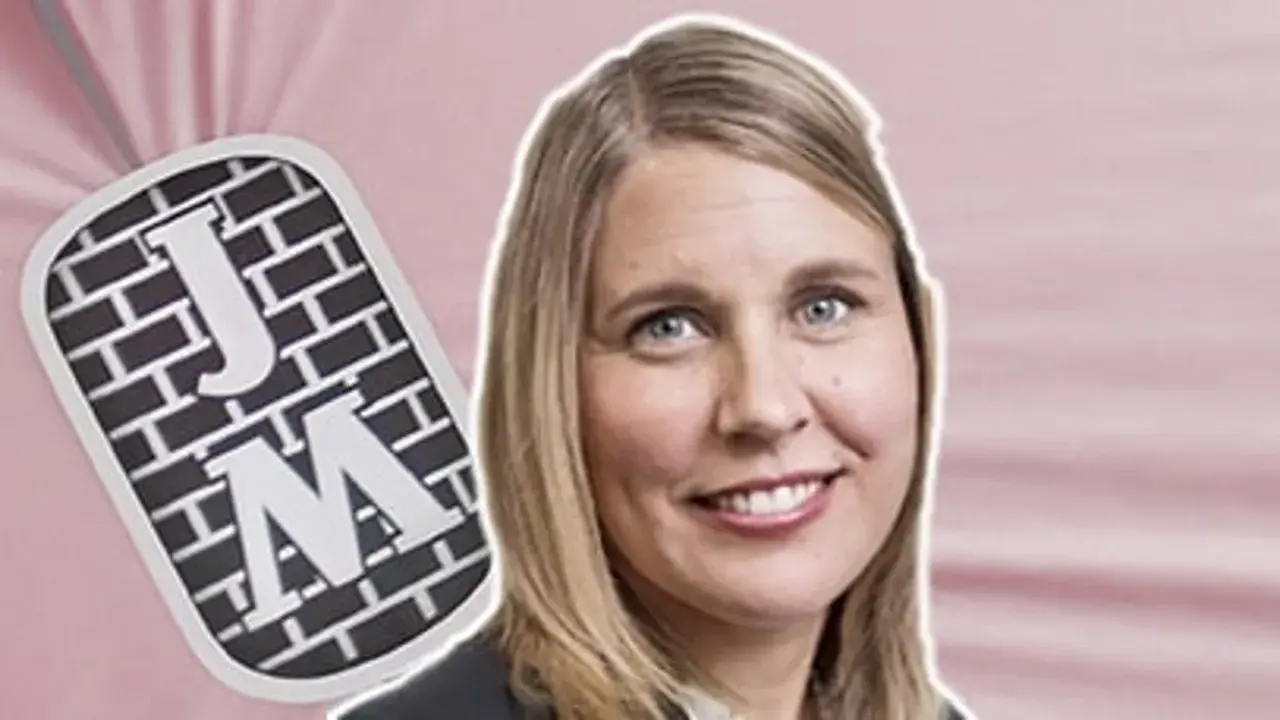 Malin Lundgren, journalist, med en bricka med bokstäverna J och M.