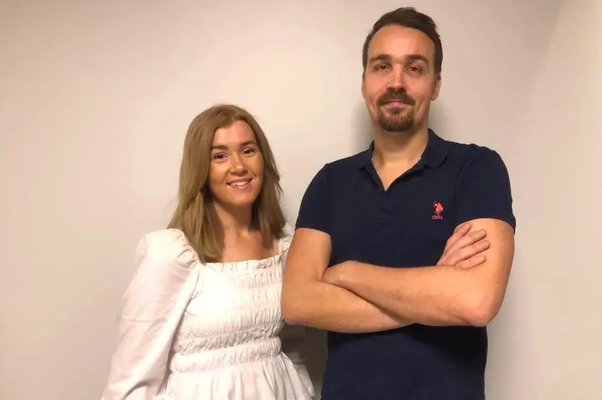 Hanna Theorin ler mot kameran bredvid en man med armarna i kors.