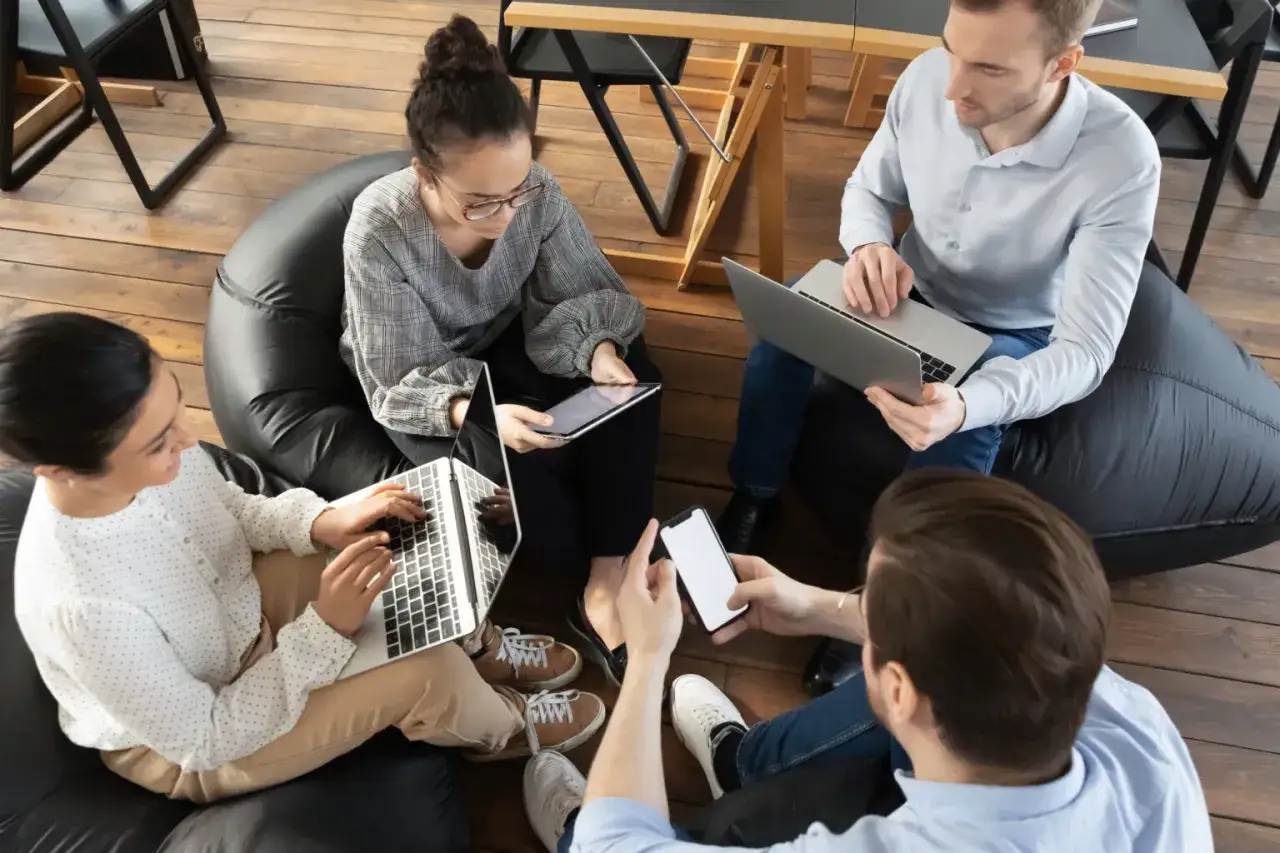 Ett team av fyra personer, inklusive en social media specialist, diskuterar id&eacute;er kring b&auml;rbara datorer och surfplattor.