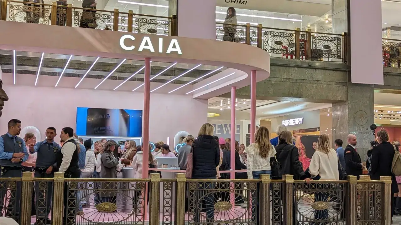 En folkmassa samlas vid en rosa CAIA pop up-butik i ett köpcentrum.