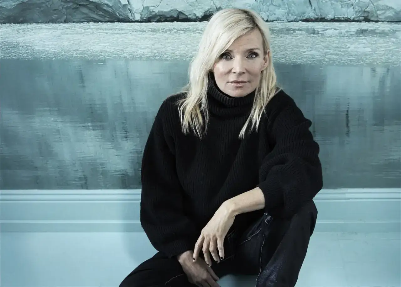 Bea Uusma, känd för sitt arbete inom barnkirurgi, sitter framför en isig bakgrund.
