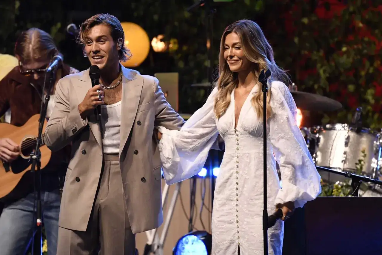 Bianca Ingrosso och en man på scen, kanske för en ny bianca ingrosso låt. En gitarrist syns i bakgrunden.