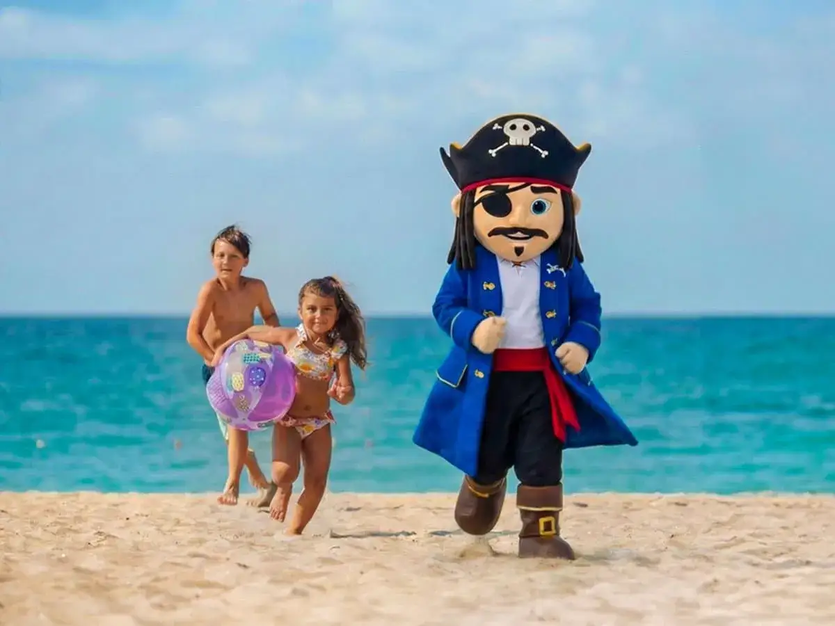 En piratmaskot leder barnen på stranden. En härlig dag för hela familjen på en svensk familjeklubb.