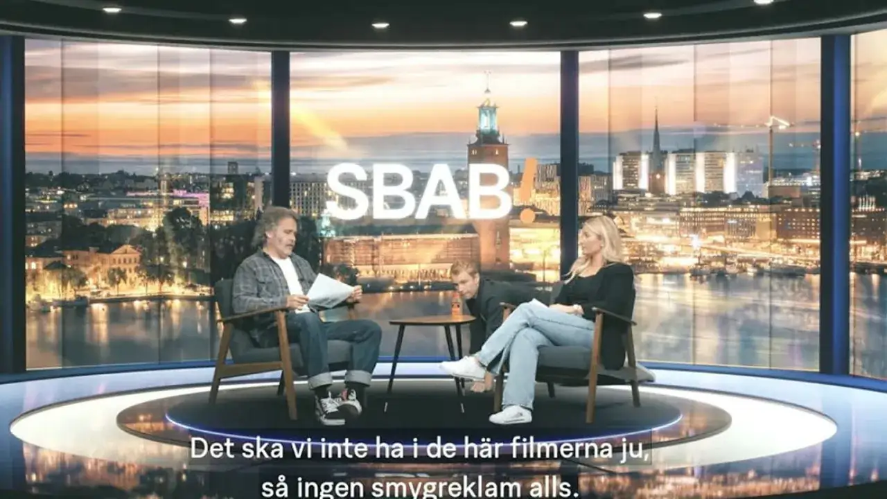 SBAB-reklam med tre personer i en studio med Stockholmsvy i bakgrunden. En man läser papper, en annan böjer sig fram, och en kvinna sitter.