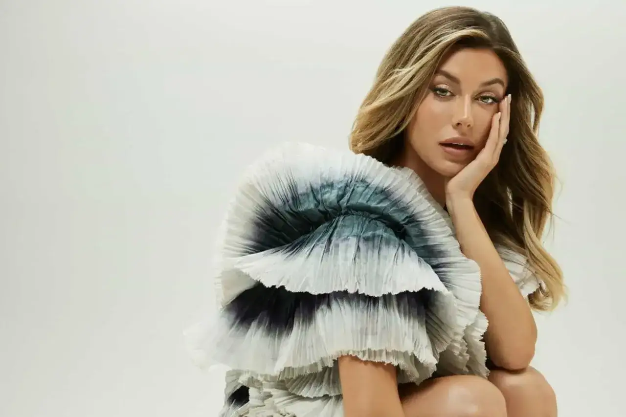 Bianca Ingrosso i en dramatisk klänning med volanger och tie-dye-mönster, poserande med handen mot ansiktet.