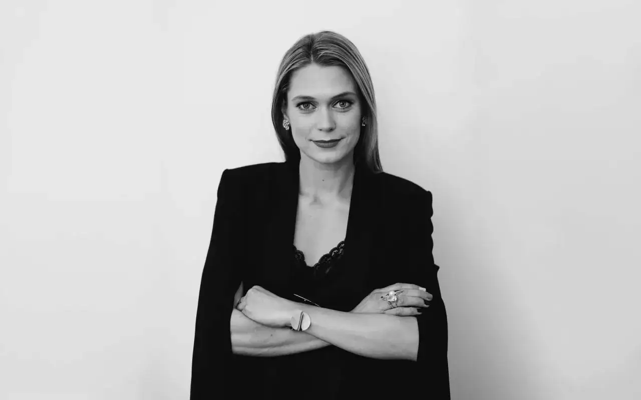 Ida Bergfeldt, en kvinna med armarna i kors, bär en elegant svart kavaj och spetslinne.