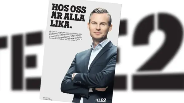 En man i kostym ler mot kameran i en Telenor reklam. Texten lyder "Hos oss är alla lika".