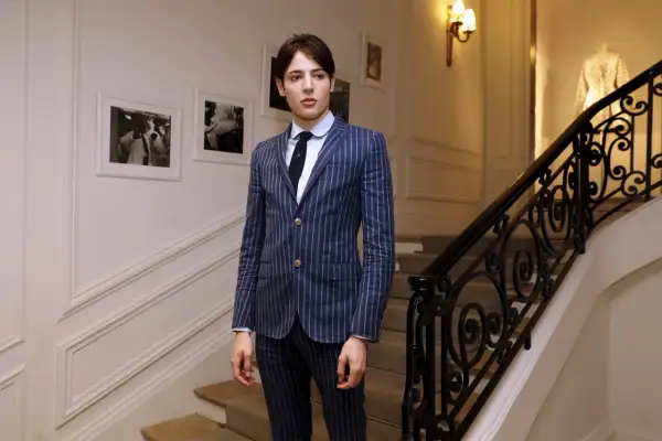 Harry Brant står på en trappa i en randig kostym.
