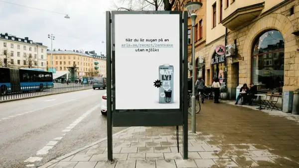 Oatly reklam på en reklamtavla i stadsmiljö. Texten uppmanar till att baka pannkakor utan mjölk.