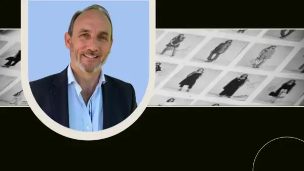 Man i kostym ler mot kameran, bredvid bilder på kläder. Perfekt för en brand manager utbildning.